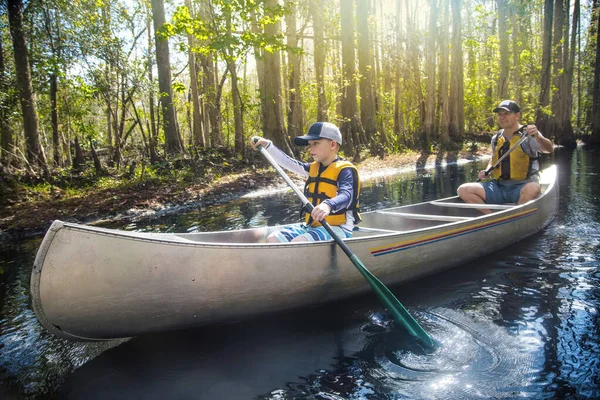 冒险的父亲和儿子在茂密的森林中的一条美丽的河流上划船 家庭假期和新的经历 在大自然中一起笑 一起玩乐 — 图库照片