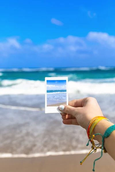 女孩手握海滩景观的即时照片 专注于手握和照片 巨大的热带旅行照片摘要 — 图库照片