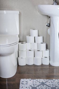 Konut banyosunda bir yığın tuvalet kağıdı rulosu. Acil durumlar için ev hazırlığı. Gerekli şeyleri stokluyoruz..