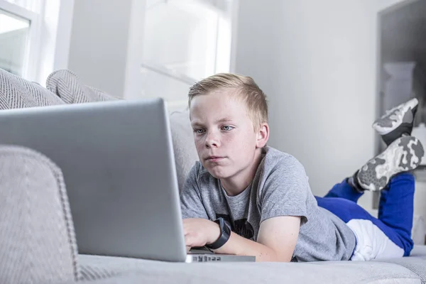 Tiener Jongen Studeren Thuis Met Behulp Van Laptop Liggend Bank — Stockfoto