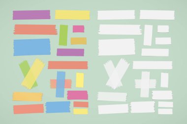 Farklı boyut renkli ve beyaz yapışkan kağıt, yapışkanlı, maskeleme bandı yeşil arka plan üzerinde sıkışmış