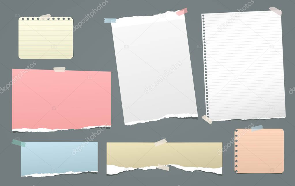 Pieces of torn colorful and white, lined note, notebook paper strips stuck on dark background
