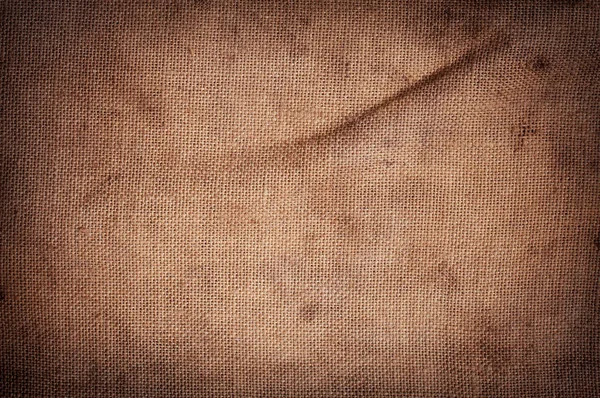 Old stained brown horizontal creasy burlap texture. — Stock Photo, Image