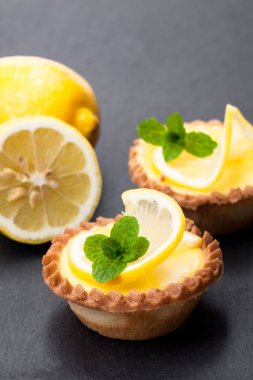 siyah arduvaz arka planda limonlu yumurta kremalı tart 