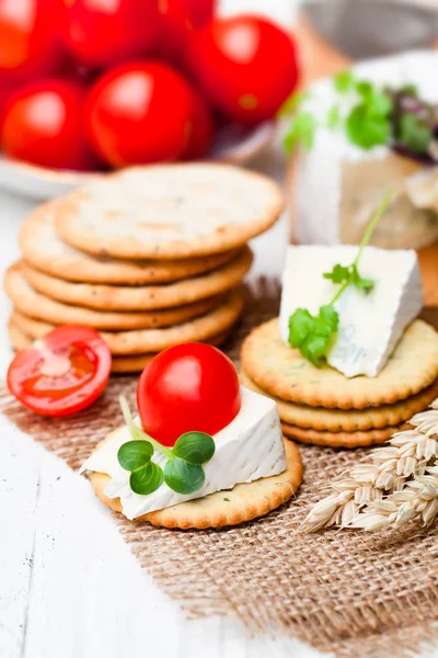 Crackers  and wedge of blue camembert cheese on sackcloth napkin — Stock Photo, Image