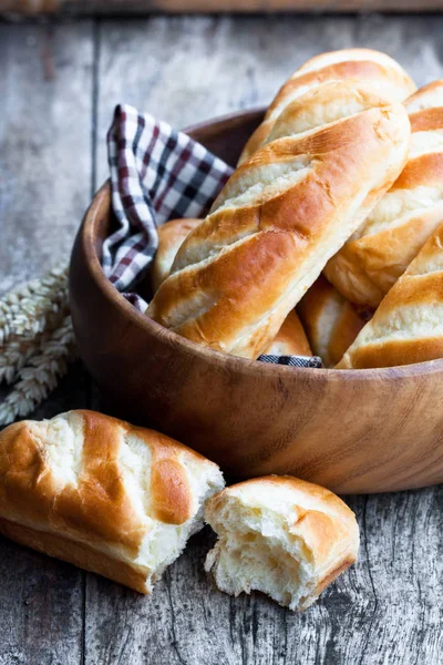 Minibrød i treskål og hveteører på trebord – stockfoto