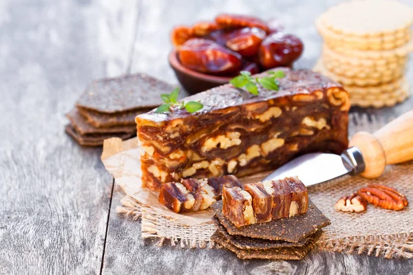 Dátum dió ék a multigrain crackerek, fából készült asztal — Stock Fotó