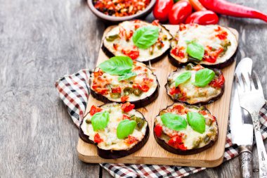 Fırında patlıcan peynir ve domates kesme tahtası üzerinde 