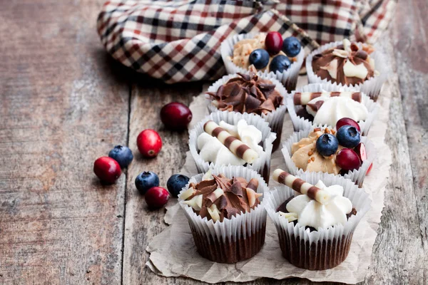 Mini cupcakes au chocolat avec chocolat et baies sur ta en bois — Photo