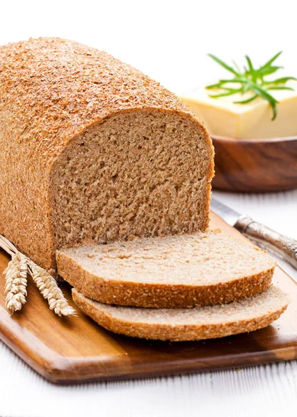 Sliced  slow-baked organic wholemeal bread with butter and rosem — Stock Photo, Image