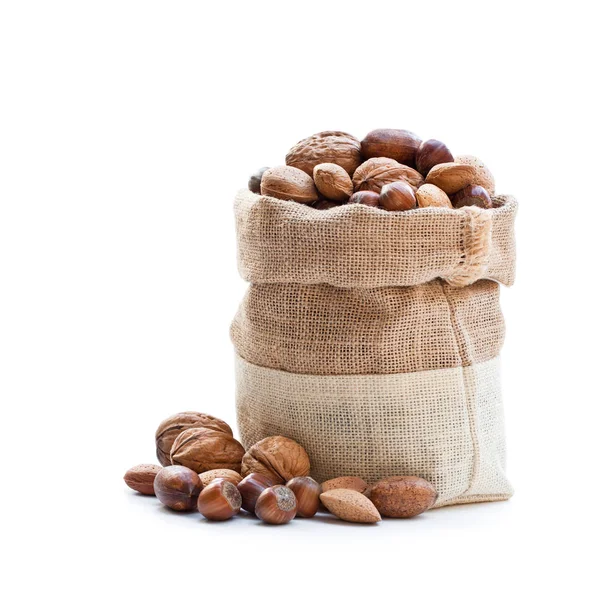 Различные орехи во власянице мешок изолирован на белом — стоковое фото
