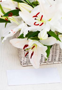 Lily çiçek kokulu beyaz tahta masada eski sepeti