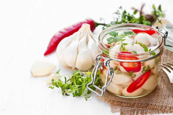 Gemarineerde knoflook met gemengde pepers en kruiden in glazen pot — Stockfoto