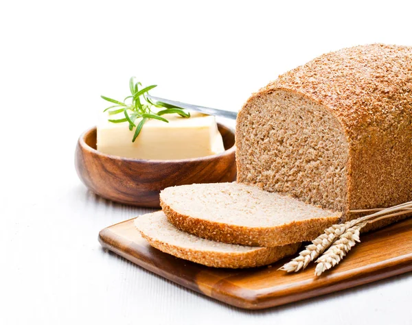 Sliced  slow-baked organic wholemeal bread with butter and rosem — Stock Photo, Image