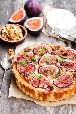 Taze incir ve rustik ahşap üzerinde keçi peyniri ile lezzetli tart