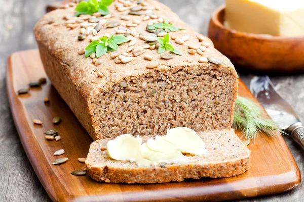 W domu, w plasterkach chleba żytniego z nasiona słonecznika i świeżego masła — Zdjęcie stockowe