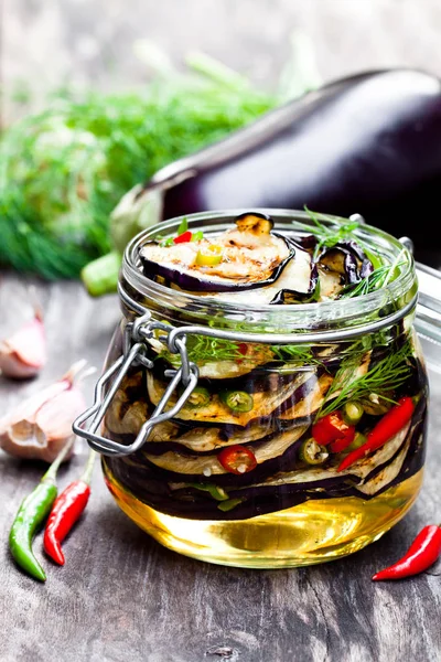 Grillad skivad aubergine med chili i glasburk på rustika bord — Stockfoto