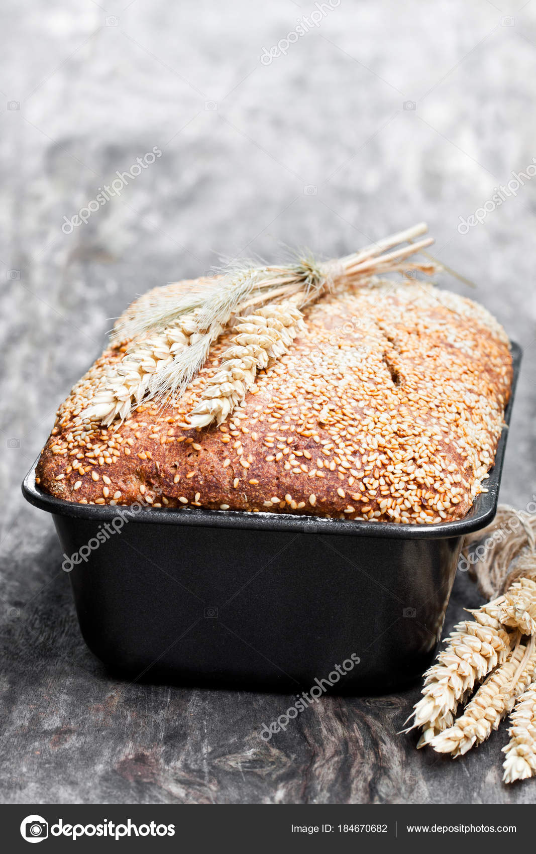 Homemade wholemeal rye bread in baking form on wooden table Stock Photo