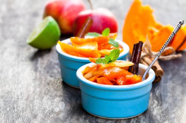 Karamelize kabak ve elma ahşap masa üzerinde küçük tencerede 