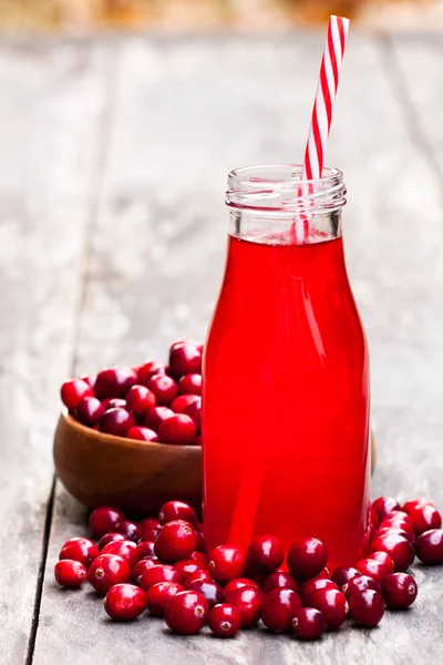 Biologische cranberry sap in fles met bessen op houten backgr — Stockfoto
