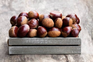 ahşap arka plan üzerinde mezarda taze çiğ kestane 