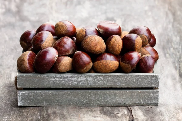 ahşap arka plan üzerinde mezarda taze çiğ kestane 