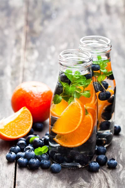 在木质背景下排毒有机蓝莓和橙汁饮料 — 图库照片