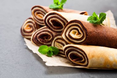 Süt ve çikolata krep siyah taş zemin üzerine haddelenmiş 