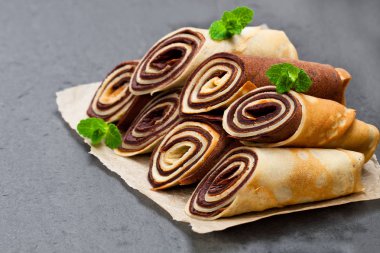 Süt ve çikolata krep siyah taş zemin üzerine haddelenmiş 