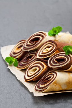 Süt ve çikolata krep siyah taş zemin üzerine haddelenmiş 