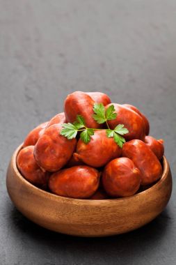 Mini chorizo sosis siyah taş zemin üzerine ahşap kase 