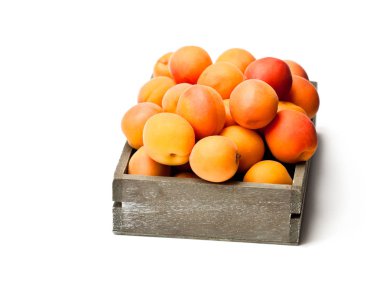 Ahşap kutu üzerinde beyaz izole üzerinde taze kayısı 