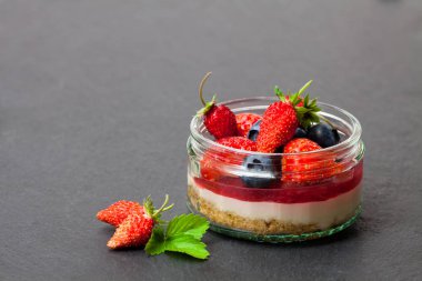 Cam Aranjman siyah sto üzerinde Mini vahşi orman meyveleri cheesecake