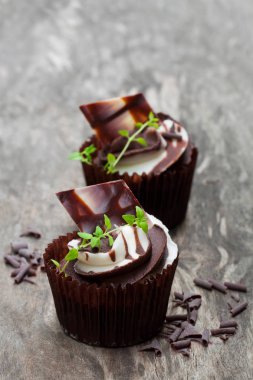 Ahşap masa üstünde kremalı çikolata cupcakes 