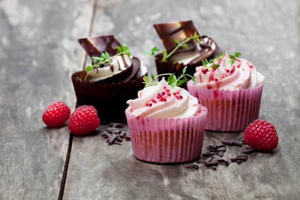 Cupcakes au chocolat avec framboises fraîches et crème sur t en bois — Photo