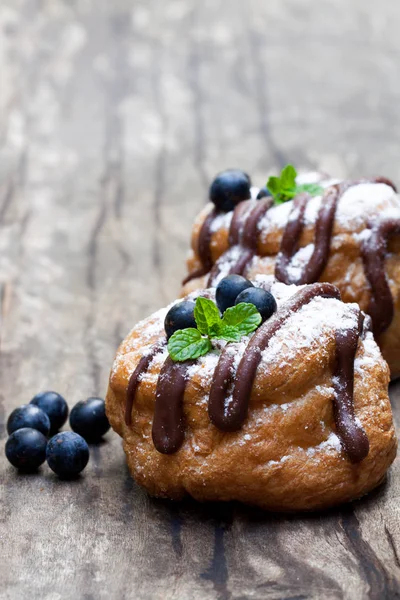 Βελγική σοκολάτα choux ψωμάκια γεμιστά με κρέμα βατόμουρου και o — Φωτογραφία Αρχείου