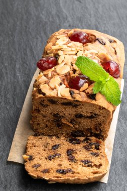 Siyah taş masada meyveli kek. 