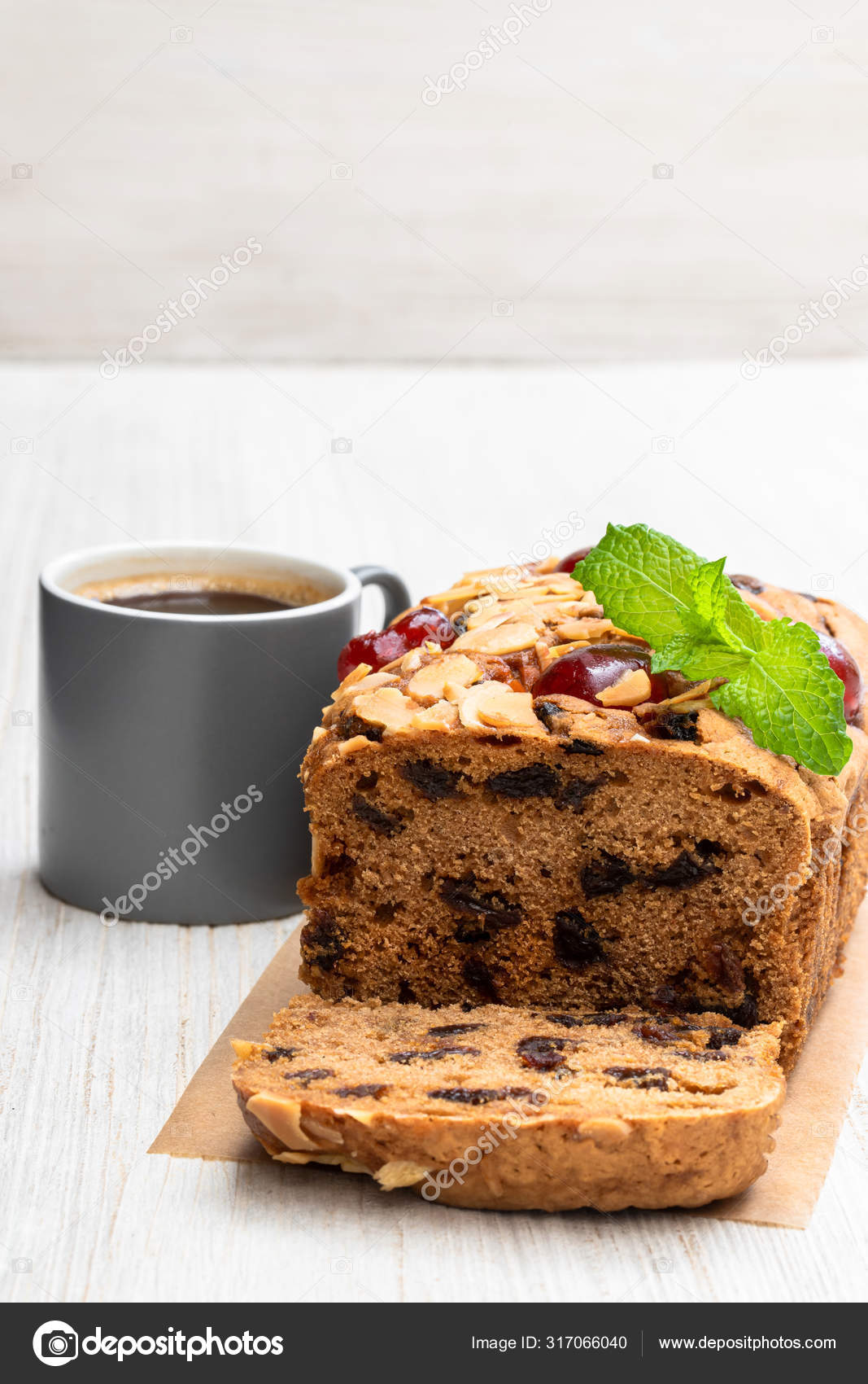 Mixed fruit loaf cake with cup of coffee on wooden table Stock Photo by