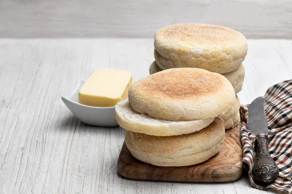 Frisch gebackene englische Muffins auf weißem Holztisch — Stockfoto