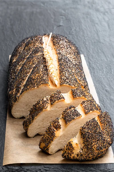 Poppy seed white loaf bread on black stone background — ストック写真
