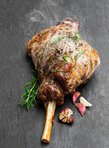 Whole roast lamb leg on black stone background — Stock Photo, Image