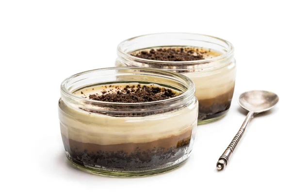 Vrstvené krémové cappuccino tvarohové koláče ve skleněné nádobě izolované na bílém — Stock fotografie