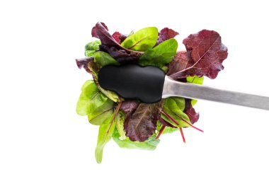 Tongs with mix salad leaves isolated on white  clipart
