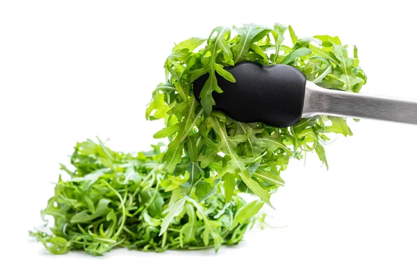 Tongs with rocket salad leaves isolated on white — Stock Photo, Image