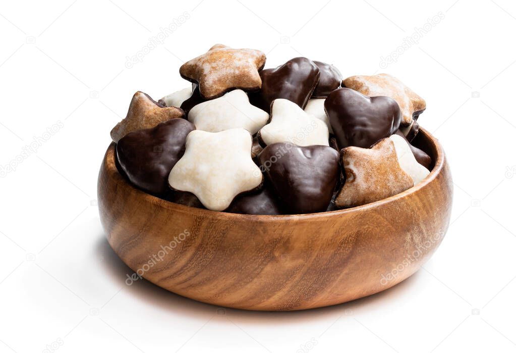 Sugar and chocolate glazed seasonal spiced cookies in wooden bowl isolated on white 