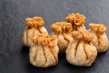 Siyah taş arka planda bir grup tavuk wonton. 