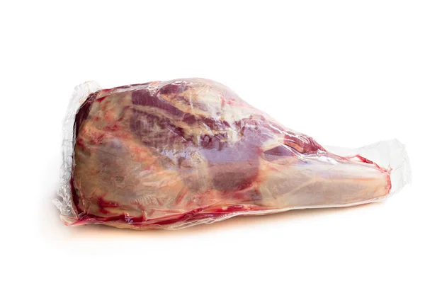Embalagem a vácuo de perna de cordeiro crua isolada sobre branco — Fotografia de Stock