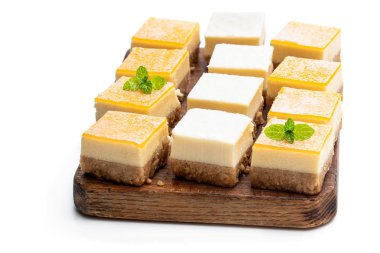 Mini limon ve vanilyalı cheesecake dilimleri beyaz üzerine izole edilmiş. 