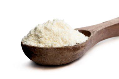 Tam yağlı süt tozu beyaz kaşıkta izole edilmiş. 