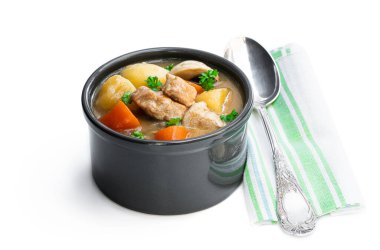 Beyazlar üzerinde izole edilmiş küçük çömlek içinde sebzeli domuz yahnisi. 